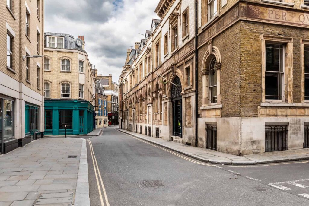 A quaint London street with historic buildings, symbolizing the foundation and enduring heritage of CMC in drug development, ensuring the safety, efficacy, and quality of pharmaceutical products.